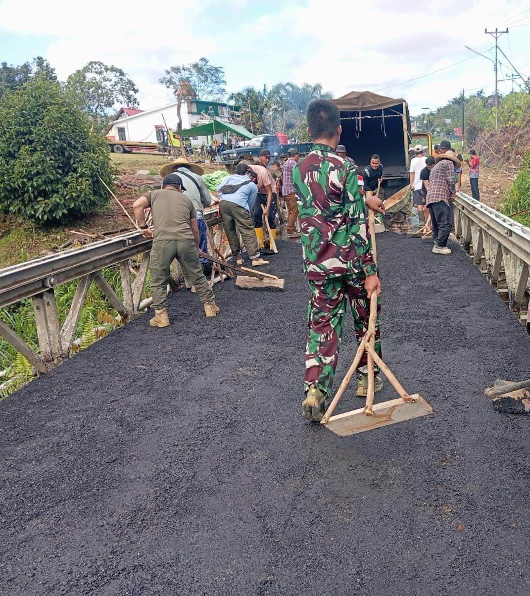 Kodim 1209/Bengkayang Dan Warga Binaan Bergotong Royong Selesaikan Pengaspalan Jembatan Sungai Ted Sampai Tahap Akhir